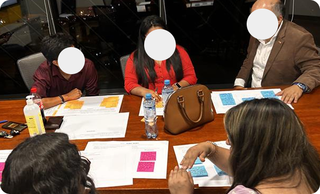 Participants working with sticky notes around a table during a workshop