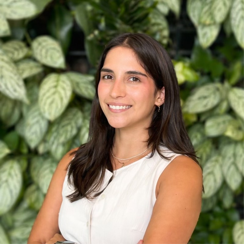 Portrait of Tiffany Macher smiling in front of green plants
